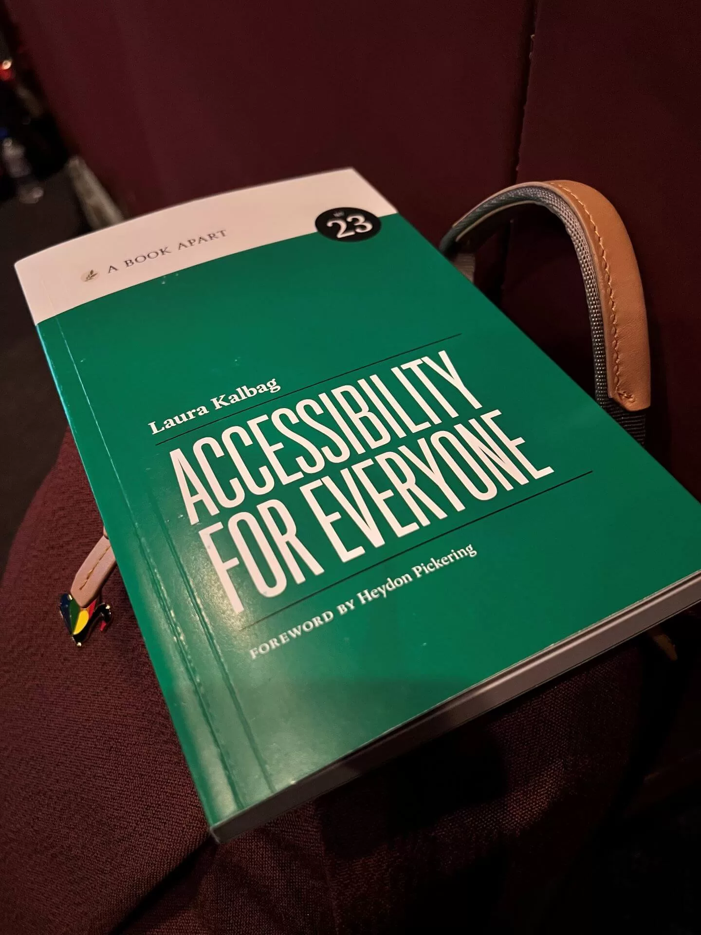 A photo of the book I won, "Accessibility for Everyone" by Laura Kalbag. It has a green cover and is resting on my backpack.